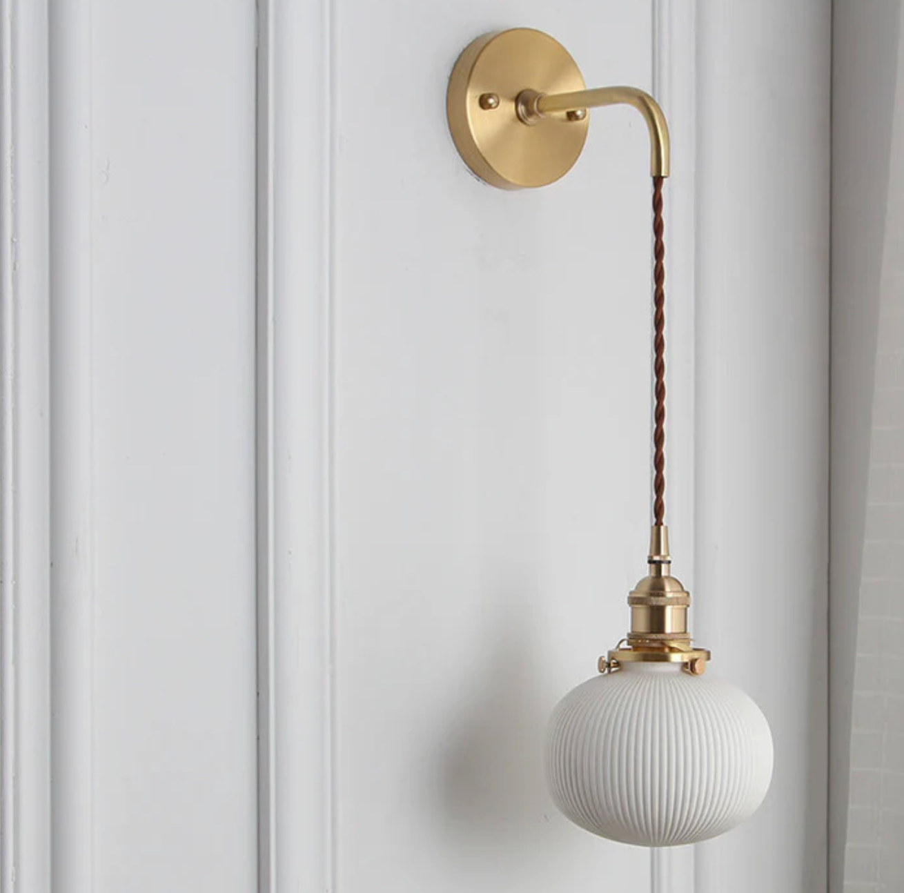Retro-style wall sconce with a frosted shade and brass finish 8