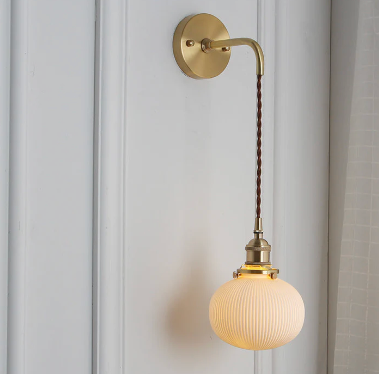 Retro-style wall sconce with a frosted shade and brass finish 9