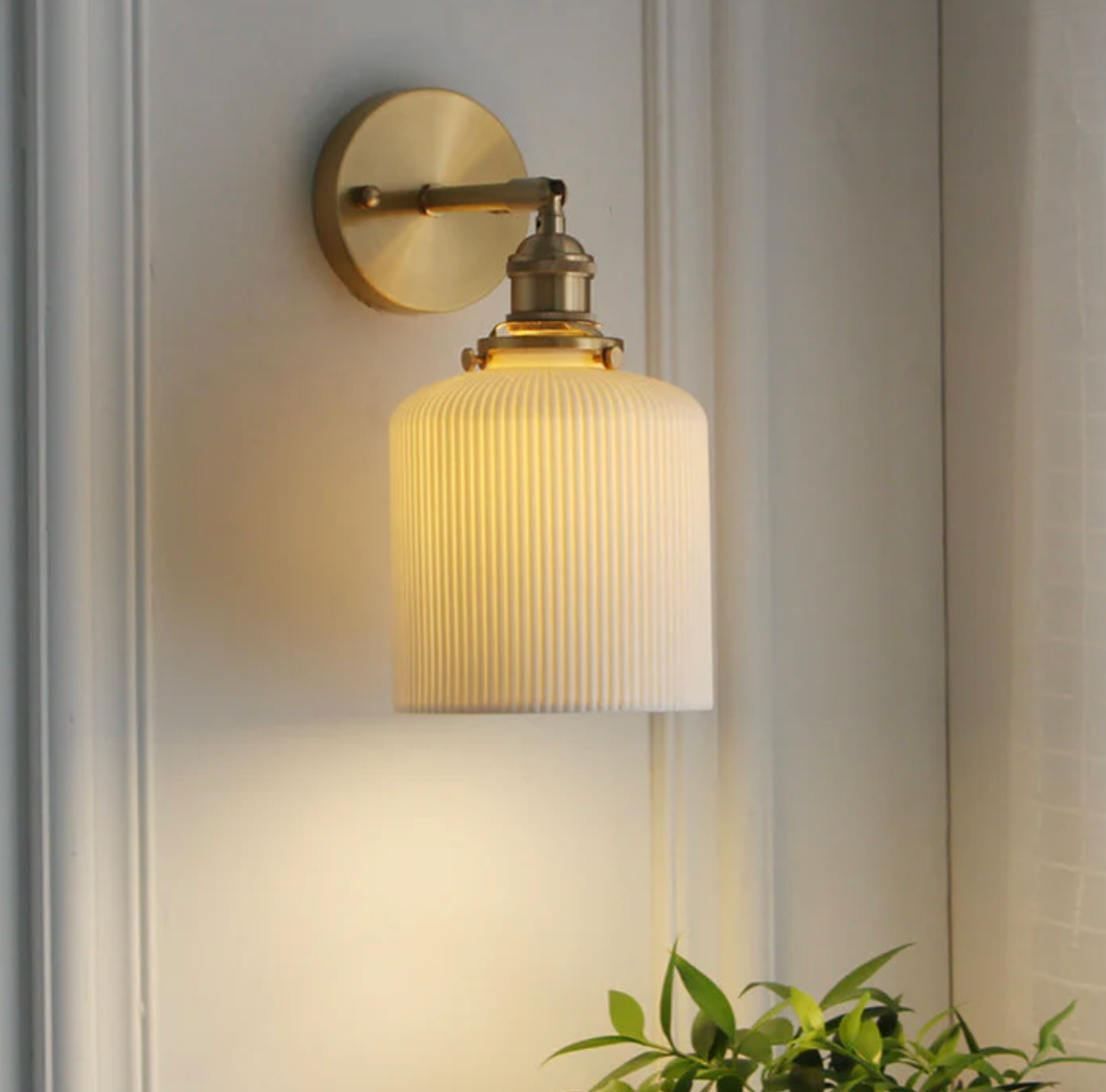 Retro-style wall sconce with a frosted shade and brass finish 0