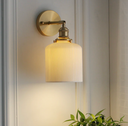 Retro-style wall sconce with a frosted shade and brass finish 0