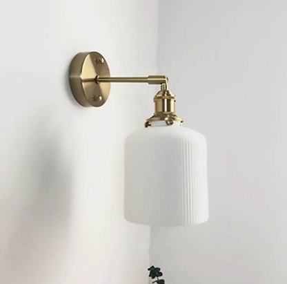 Retro-style wall sconce with a frosted shade and brass finish 1