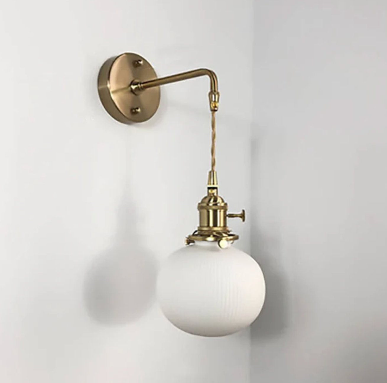 Retro-style wall sconce with a frosted shade and brass finish 3