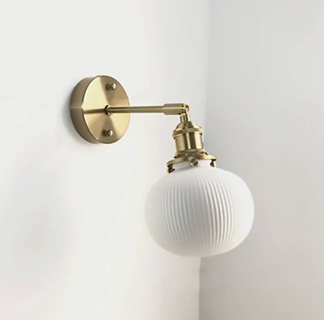 Retro-style wall sconce with a frosted shade and brass finish 4