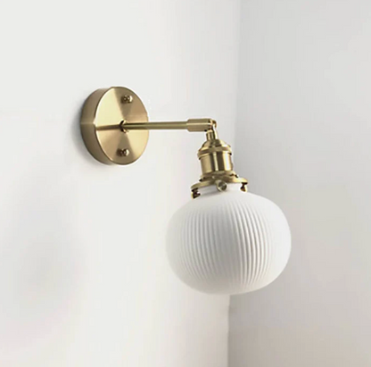 Retro-style wall sconce with a frosted shade and brass finish 4