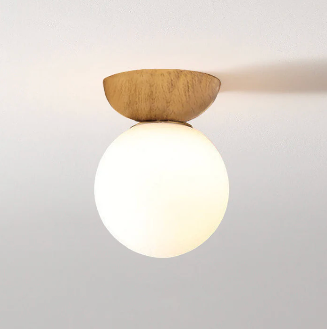 A ceiling or pendant lamp with a frosted shade and a wooden accent – minimalist elegance for any interior 0